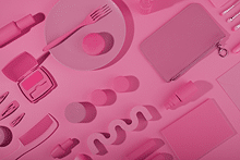 Elementos aleatorios de color rosa como un plato, una cartera, un peine, maquillaje, etc.